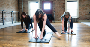 Three women stretching their bodies as an exercise session