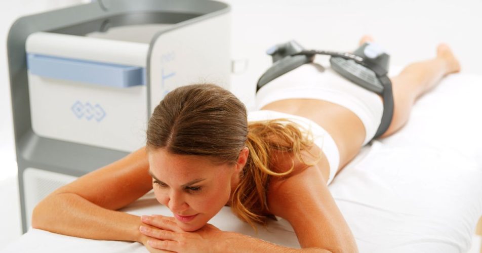 woman lying on her stomach doing an emsculpt neo treatment
