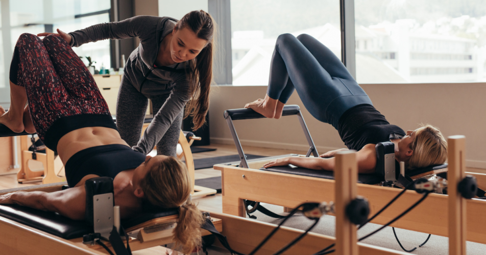 Two beautiful ladies working out with their gym instructor.